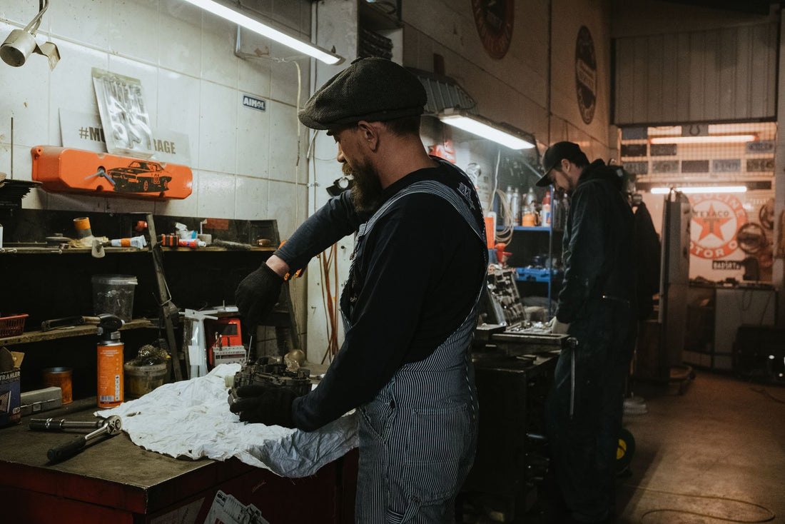 Mechanics at work in a repair shop, matching the right part